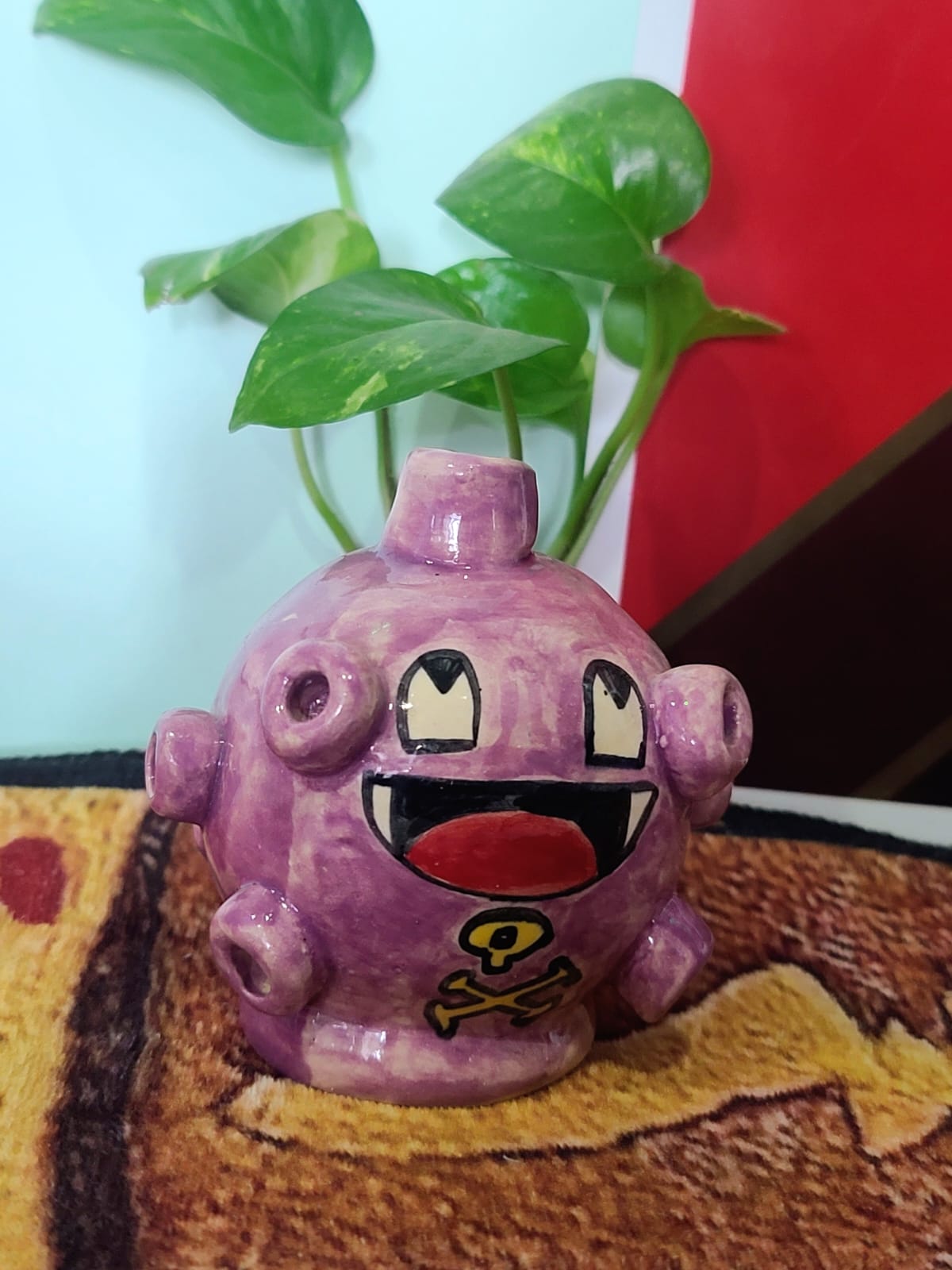 Pieza de cerámica morada pintada a mano